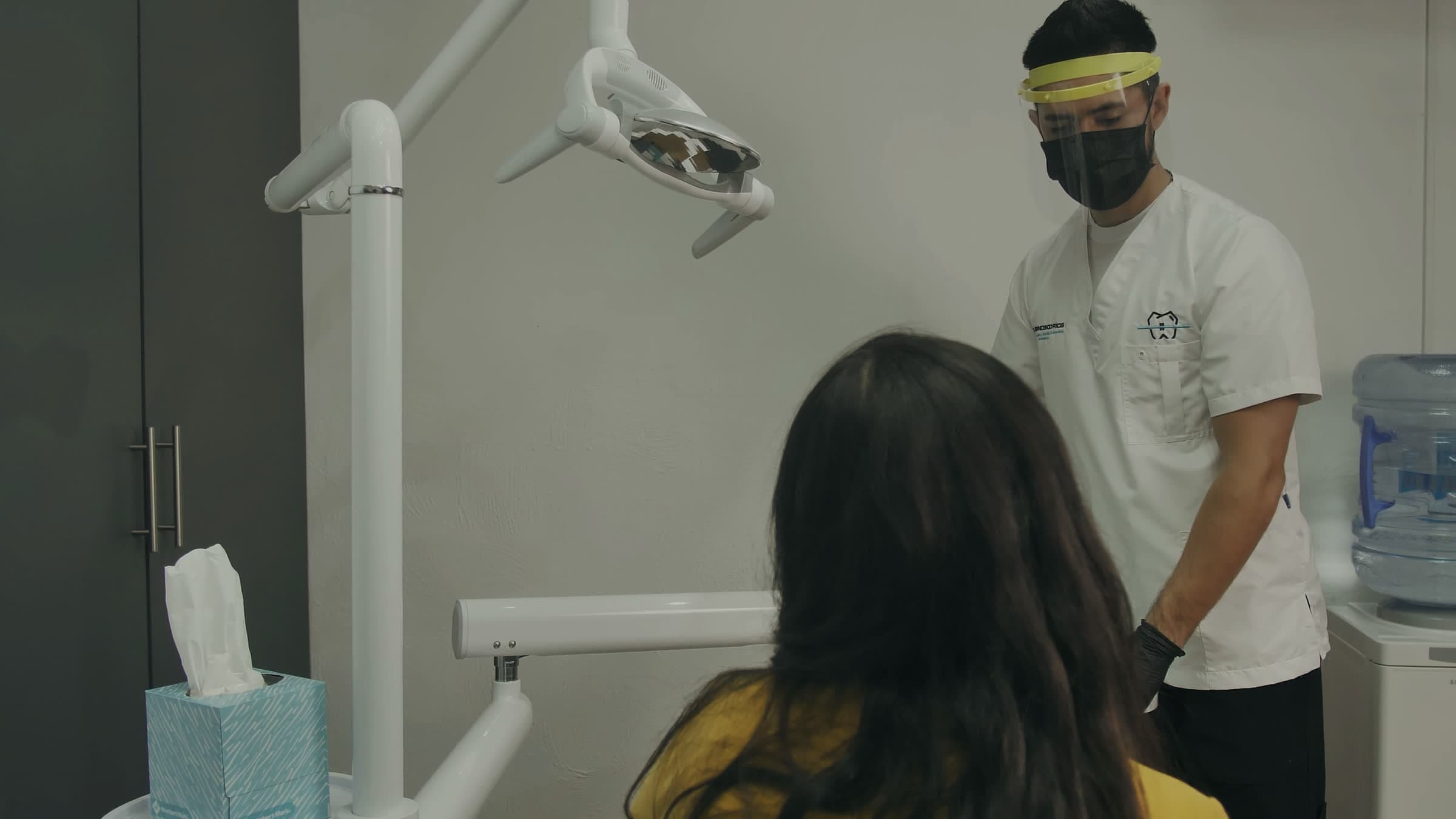 A patient sitting down in the dental chair while the dentist gets ready