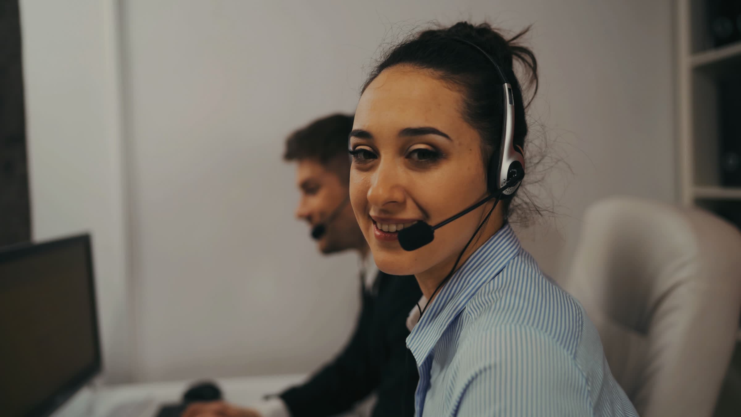 Two people on headsets making calls at their desks