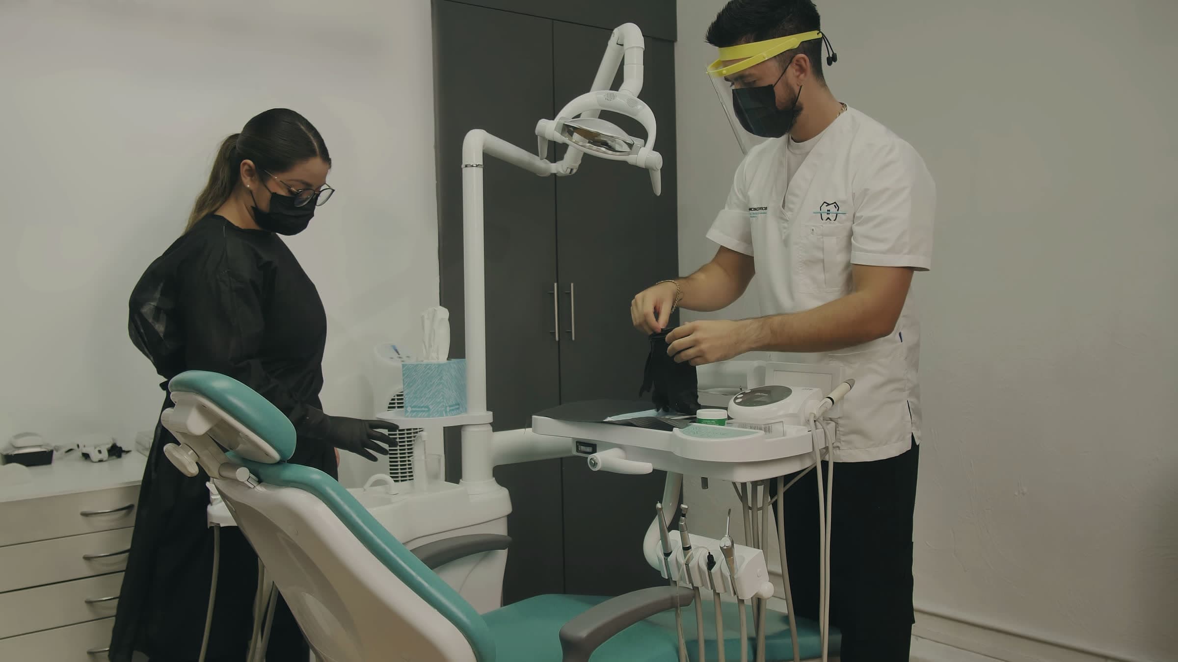 A dentist and his assistant setting up the dental chair for the next patient