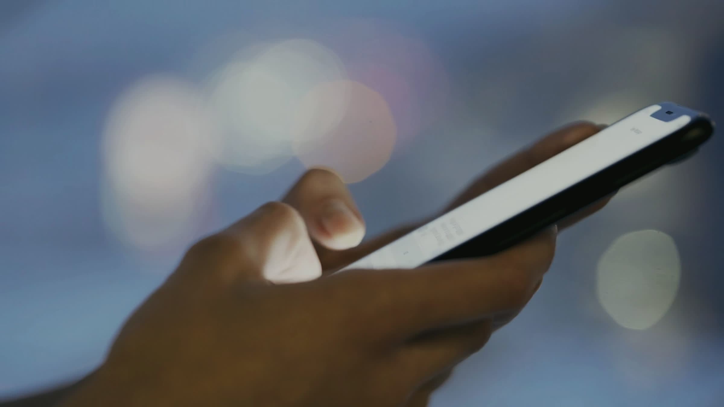 A hand holding a phone, typing a text message